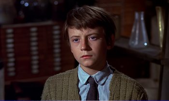 Movie still from “Bedknobs and Broomsticks” (1971), directed by Ward Kimball – A young man wearing a sweater and a tie; Close Up shot, High angle