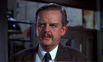Movie still from “Bedknobs and Broomsticks” (1971), directed by Ward Kimball – An older man wearing a suit and a tie; Close Up shot, Low angle