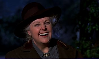 Movie still from “Bedknobs and Broomsticks” (1971), directed by Ward Kimball – An older woman wearing a hat and a jacket; Close Up shot, Over the shoulder angle