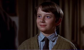 Movie still from “Bedknobs and Broomsticks” (1971), directed by Ward Kimball – A young boy wearing a sweater and a tie; Close Up shot, Low angle