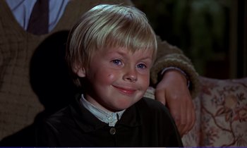 Movie still from “Bedknobs and Broomsticks” (1971), directed by Ward Kimball – A young boy smiling for the camera; Close Up shot, High angle