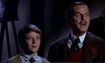 Movie still from “Bedknobs and Broomsticks” (1971), directed by Ward Kimball – A man and a boy standing next to each other; Close Up shot, Low angle