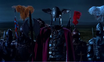 Movie still from “Bedknobs and Broomsticks” (1971), directed by Ward Kimball – A man in a helmet and a cape; Medium shot, Low angle