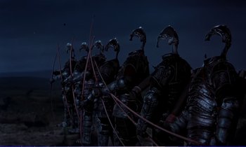 Movie still from “Bedknobs and Broomsticks” (1971), directed by Ward Kimball – A group of people dressed in armor and holding arrows; Wide shot, Low angle
