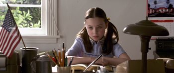 Movie still from “Bedtime Stories” (2008), directed by Adam Shankman – A young girl sitting at a table with a book and pencils; Close Up shot, High angle