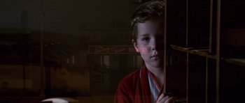 Movie still from “Bedtime Stories” (2008), directed by Adam Shankman – A young boy in a red robe looking at the camera; Close Up shot, Low angle