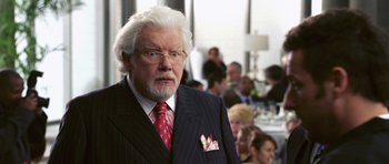 Movie still from “Bedtime Stories” (2008), directed by Adam Shankman – An older man in a suit and a red tie; Close Up shot, Over the shoulder angle