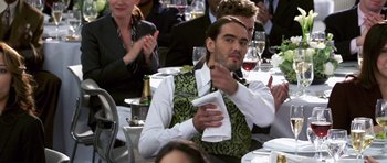 Movie still from “Bedtime Stories” (2008), directed by Adam Shankman – A group of people sitting at a table with wine glasses; Medium shot, Over the shoulder angle