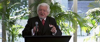 Movie still from “Bedtime Stories” (2008), directed by Adam Shankman – An older man wearing a suit and a red neck tie; Medium shot, High angle