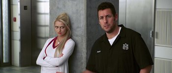 Movie still from “Bedtime Stories” (2008), directed by Adam Shankman – A man and a woman standing next to each other in front of a concrete wall; Medium shot, Over the shoulder angle