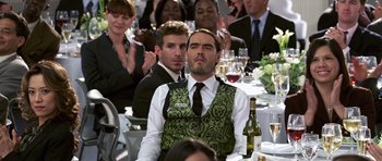 Movie still from “Bedtime Stories” (2008), directed by Adam Shankman – A group of people sitting at a table with wine glasses; Medium shot, Over the shoulder angle