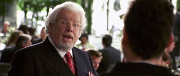 Movie still from “Bedtime Stories” (2008), directed by Adam Shankman – An older man wearing a suit and tie talking to a man in a suit; Close Up shot, Over the shoulder angle