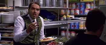 Movie still from “Bedtime Stories” (2008), directed by Adam Shankman – A man sitting in front of some food in a kitchen; Close Up shot, Over the shoulder angle