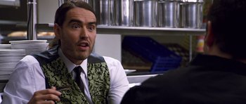 Movie still from “Bedtime Stories” (2008), directed by Adam Shankman – A man in a green and black vest is talking to someone; Close Up shot, Over the shoulder angle