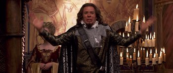 Movie still from “Bedtime Stories” (2008), directed by Adam Shankman – A man dressed as a medieval knight in front of a painting; Medium shot, Over the shoulder angle