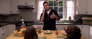 Movie still from “Bedtime Stories” (2008), directed by Adam Shankman – A man talking on a phone in a kitchen; Medium shot, Over the shoulder angle