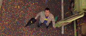 Movie still from “Bedtime Stories” (2008), directed by Adam Shankman – A young man standing on the floor of a room full of confetti; Wide shot, Overhead angle