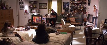 Movie still from “Bedtime Stories” (2008), directed by Adam Shankman – A man sitting on a bed in front of a tv; Wide shot, High angle