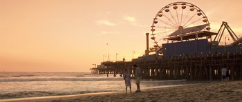Movie still from “Bedtime Stories” (2008), directed by Adam Shankman – Two people standing on the beach near the pier; Extreme Wide shot, Low angle