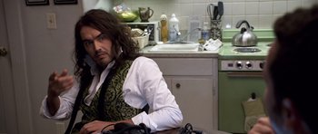 Movie still from “Bedtime Stories” (2008), directed by Adam Shankman – A man sitting at a kitchen counter with a phone; Close Up shot, High angle