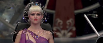 Movie still from “Bedtime Stories” (2008), directed by Adam Shankman – A woman in a purple dress and a gold necklace; Close Up shot, Over the shoulder angle