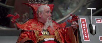 Movie still from “Bedtime Stories” (2008), directed by Adam Shankman – An old man dressed in a red and gold costume; Medium shot, Over the shoulder angle