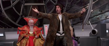 Movie still from “Bedtime Stories” (2008), directed by Adam Shankman – A man wearing a brown coat and a white t - shirt; Medium shot, Low angle