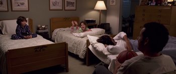 Movie still from “Bedtime Stories” (2008), directed by Adam Shankman – A girl laying in a bed next to a man and a woman; Wide shot, High angle