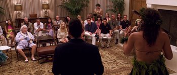 Movie still from “Bedtime Stories” (2008), directed by Adam Shankman – A group of people sitting in a circle with a man in a black suit; Wide shot, High angle