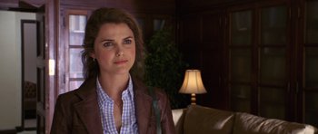 Movie still from “Bedtime Stories” (2008), directed by Adam Shankman – A woman standing in front of a lamp in a living room; Close Up shot, Over the shoulder angle