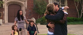Movie still from “Bedtime Stories” (2008), directed by Adam Shankman – A man and a woman hug in front of a woman and a boy; Wide shot, Over the shoulder angle