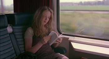 Movie still from “Before Sunrise” (1995), directed by Richard Linklater – A woman sitting in a chair reading a book; Medium shot, High angle
