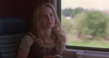 Movie still from “Before Sunrise” (1995), directed by Richard Linklater – A beautiful young woman sitting in front of a window; Close Up shot, Over the shoulder angle