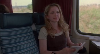 Movie still from “Before Sunrise” (1995), directed by Richard Linklater – A woman sitting on a seat on a train; Medium shot, Over the shoulder angle