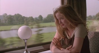 Movie still from “Before Sunrise” (1995), directed by Richard Linklater – A woman sitting in front of a window on a train; Medium shot, Over the shoulder angle