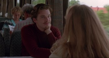 Movie still from “Before Sunrise” (1995), directed by Richard Linklater – A man sitting in front of a woman in front of another man; Close Up shot, Over the shoulder angle
