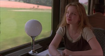 Movie still from “Before Sunrise” (1995), directed by Richard Linklater – A woman sitting in front of a window on a train; Medium shot, Low angle