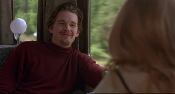 Movie still from “Before Sunrise” (1995), directed by Richard Linklater – A man sitting next to a woman on a train; Medium shot, Over the shoulder angle