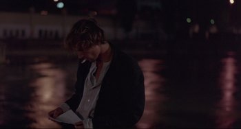 Movie still from “Before Sunrise” (1995), directed by Richard Linklater – A man standing in the dark with a cigarette in his mouth; Medium shot, High angle