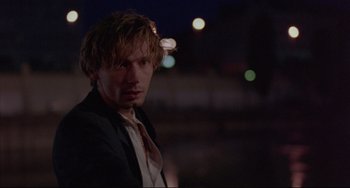 Movie still from “Before Sunrise” (1995), directed by Richard Linklater – A man in a suit and tie standing in front of lights; Close Up shot, Low angle
