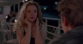 Movie still from “Before Sunrise” (1995), directed by Richard Linklater – A woman sitting in front of a man in front of a railing at night; Close Up shot, Over the shoulder angle