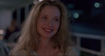 Movie still from “Before Sunrise” (1995), directed by Richard Linklater – A person with long hair smiling; Close Up shot, Over the shoulder angle