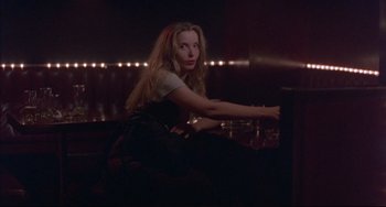 Movie still from “Before Sunrise” (1995), directed by Richard Linklater – A woman sitting at a table in a dark room; Medium shot, Over the shoulder angle