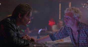 Movie still from “Before Sunrise” (1995), directed by Richard Linklater – Two people sitting at a table holding hands at a restaurant; Close Up shot, Over the shoulder angle