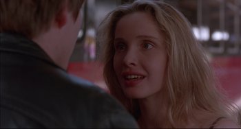 Movie still from “Before Sunrise” (1995), directed by Richard Linklater – A young woman smiles at a young man in front of a building; Close Up shot, Over the shoulder angle