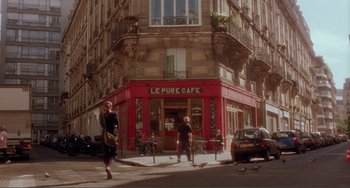 Movie still from “Before Sunset” (2004), directed by Richard Linklater – A woman walking down the street in front of a cafe; Wide shot, Low angle