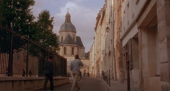 Movie still from “Before Sunset” (2004), directed by Richard Linklater – People walking down a street with a church in the background; Extreme Wide shot, Low angle