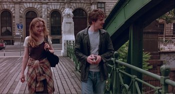 Movie still from “Before Sunset” (2004), directed by Richard Linklater – A man and a woman walking across a bridge; Medium shot, Low angle