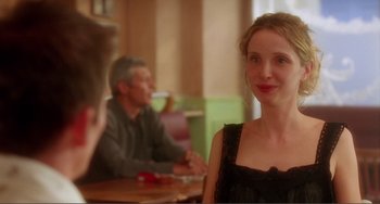 Movie still from “Before Sunset” (2004), directed by Richard Linklater – A woman in a black dress sitting in front of a man; Close Up shot, Over the shoulder angle