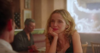 Movie still from “Before Sunset” (2004), directed by Richard Linklater – A woman sitting in front of a man in a room; Close Up shot, Over the shoulder angle